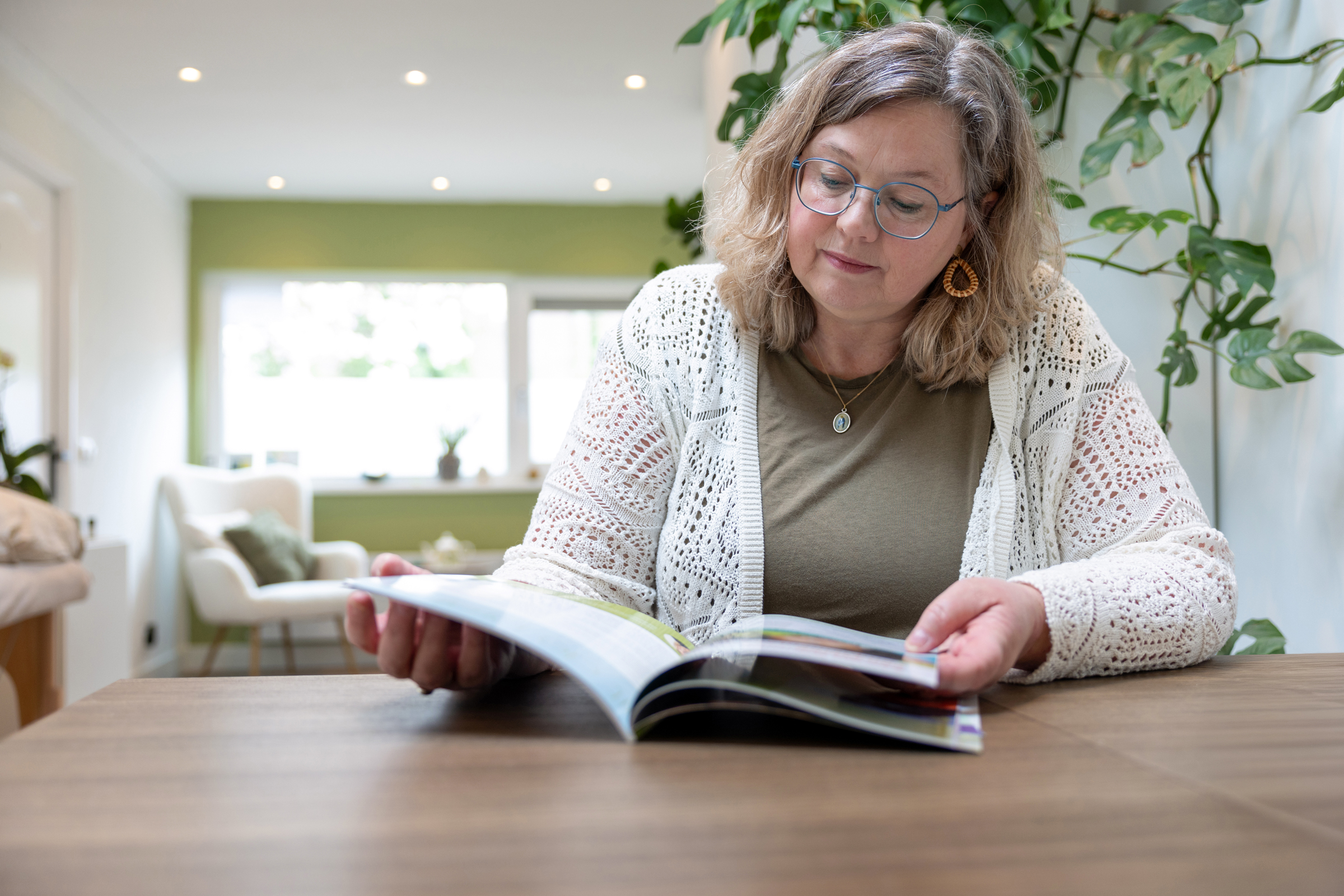 Daniëlle Bossewinkel, traumatherapeut in Harderwijk, zit rustig te lezen in haar praktijkruimte.
