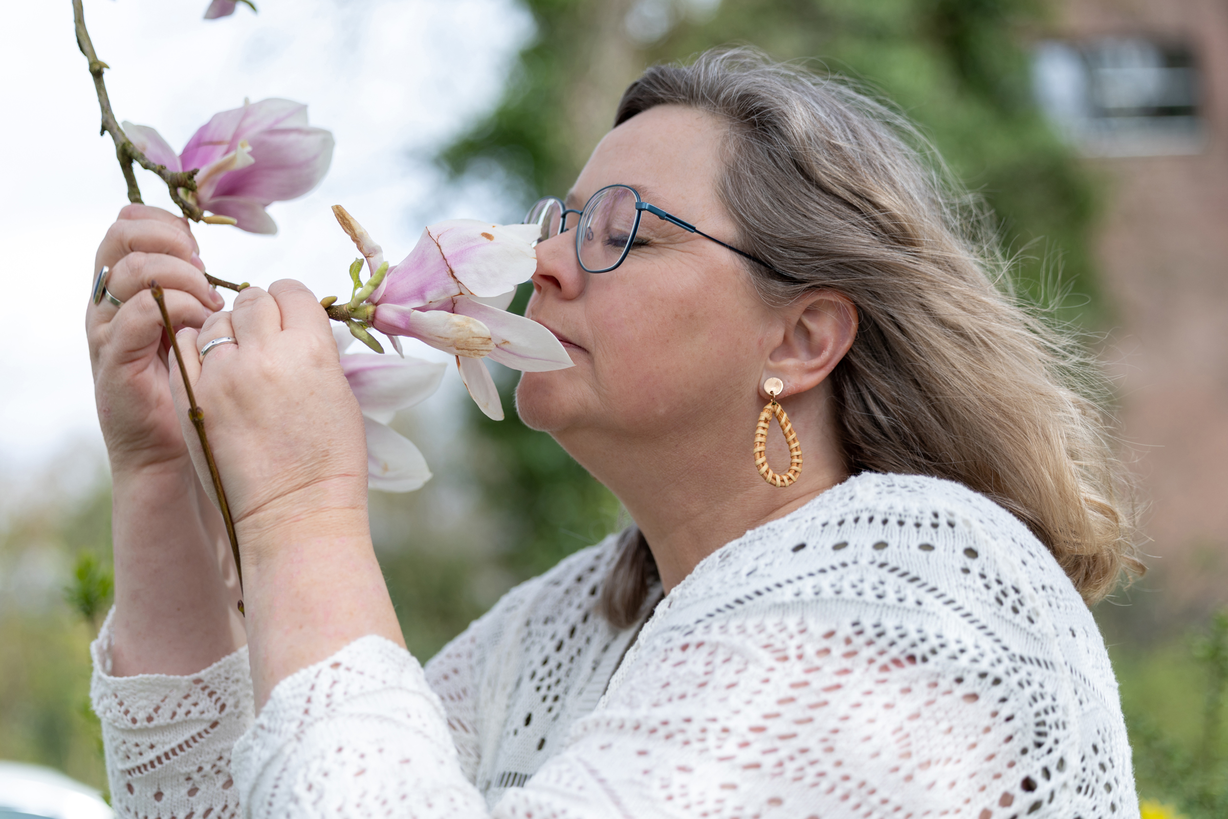 Daniëlle Bossewinkel, traumatherapeut in Harderwijk, buiten met een magnolia in haar handen.